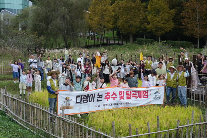 [통영=뉴시스] 신정철 기자 = 통영시지속가능발전교육재단은 18일, 통영시 용남면 통영RCE세자트라숲 다랭이논에서 초등학생과 가족 등 60여 명이 참여한 가운데 전통 방식의 추수 및 탈곡 체험을 진행했다. 사진은 벼 추수 체험 모습.(사진=통영RCE 제공).2025.10.18. photo@newsis.com *재판매 및 DB 금지