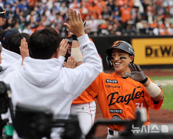 [대전=뉴시스] 김진아 기자 = 18일 대전 중구 한화생명볼파크에서 열린 2025 KBO 포스트시즌 삼성 라이온즈와 한화 이글스의 경기, 2회말 2사 만루 한화 문현빈이 역전 3타점 2루타 때 홈으로 들어온 손아섭이 기뻐하고 있다. 2025.10.18. bluesoda@newsis.com