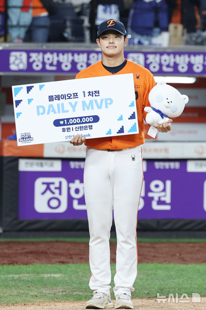 [대전=뉴시스] 김진아 기자 = 18일 대전 중구 한화생명볼파크에서 열린 2025 KBO 포스트시즌 플레이오프 1차전 삼성 라이온즈와 한화 이글스의 경기, 한화가 9-8로 승리했다. 데일리 MVP로 선정된 한화 문동주가 기념촬영을 하고 있다. 2025.10.18. bluesoda@newsis.com