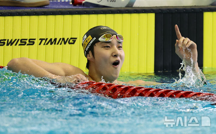 [부산=뉴시스] 황준선 기자 = 김우민(강원도청)이 18일 부산 동래구 부산사직종합운동장 실내수영장에서 열린 제106회 전국체육대회남자 경영 남자 일반부 자유형 1500ｍ 결승전을 마친 뒤 결과를 확인하며 기뻐하고 있다. 2025.10.18. hwang@newsis.com