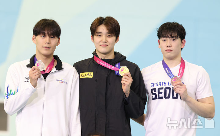 [부산=뉴시스] 황준선 기자 = 18일 부산 동래구 부산사직종합운동장 실내수영장에서 열린 제106회 전국체육대회남자 경영 남자 일반부 자유형 1500ｍ 시상식에서 1위를 차지한 김우민(가운데, 강원도청)와 2위를 차지한 김영현(왼쪽, 전주시청), 3위를 차지한 조승빈(서울시청)이 기념촬영 하고 있다. 2025.10.18. hwang@newsis.com