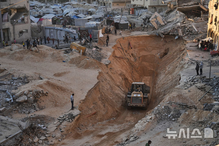[AP/뉴시스] 18일 칸유니스에서 하마스 요원들이 이스라엘 인질 시신들을 찾기 위해 땅을 파헤치고 있다