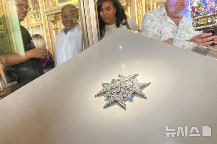 [AP/뉴시스] 강도가 훔쳐가기&nbsp; 한 달 전의 아폴로 갤러리의 보석 전시물을 관람객들이 구경하고 있다 