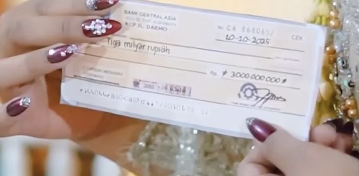 [서울=뉴시스] 인도네시아에서 74세 남성이 자신보다 50세 어린 여성과 결혼하며 30억 루피아(약 2억 5800만원)에 달하는 신붓값을 지불한 결혼식이 '사기 결혼' 논란에 휩싸였다. 사진은 결혼식 당시 신부가 받은 루피아 수표의 모습. (사진 = 틱톡 캡처) 2025.10.19. *재판매 및 DB 금지