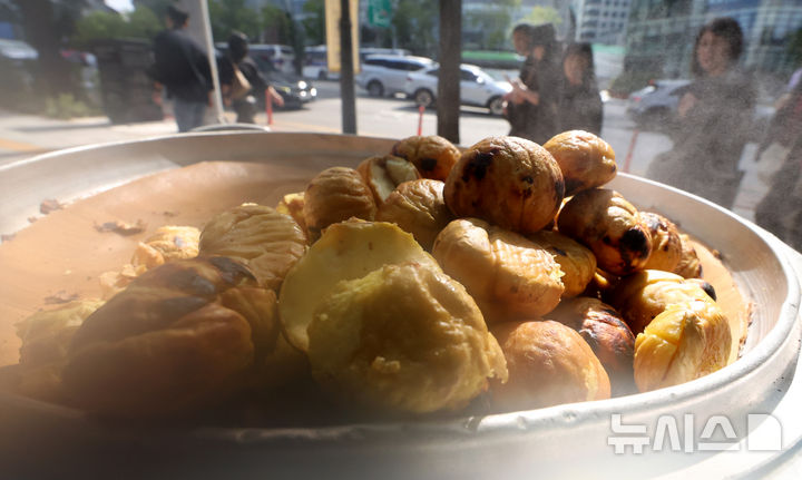 [서울=뉴시스] 추상철 기자 = 19일 오후 서울 시내에서 행인이 군밤을 바라보며 길을 지나고 있다.  기상청에 따르면 내일 아침 최저기온이 10도 이상 떨어져 쌀쌀한 날씨를 보일 전망이다. 2025.10.19. scchoo@newsis.com