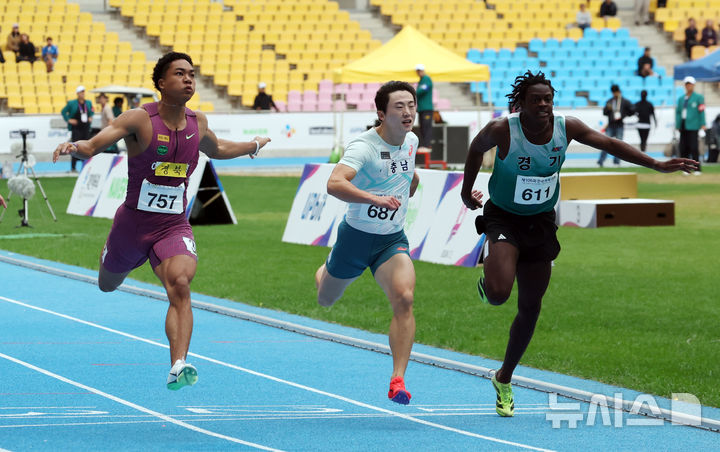  [부산=뉴시스] 하경민 기자 = 제106회 부산 전국체육대회 육상 100m 남자부 결승전이 열린 19일 부산 연제구 부산아시아드주경기장에서 나마디 조엘 진(예천군청)이 10.35초 1위의 기록으로 결승선을 통과하고 있다. 2025.10.19. yulnetphoto@newsis.com