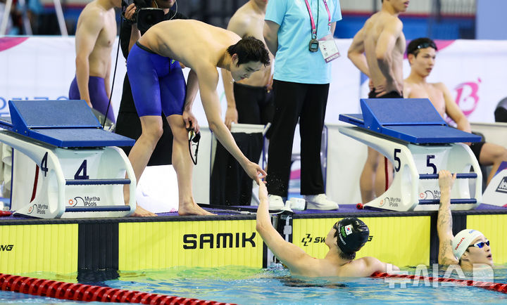 [부산=뉴시스] 황준선 기자 = 강원도청 김우민과 황선우가 19일 부산 동래구 부산사직종합운동장 실내수영장에서 열린 제106회 전국체육대회 경영 남자 일반부 계영 800m에서 1위로 경기를 마친 뒤 기뻐하고 있다. 2025.10.19. hwang@newsis.com