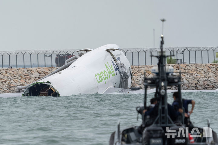 [홍콩=AP/뉴시스] 20일(현지 시간) 홍콩 국제공항에서 화물기 한 대가 활주로를 이탈해 일부가 바다에 잠겨 있다. 현지 당국은 이날 새벽 두바이발 아랍에미리트(UAE) 항공 EK9788 화물기가 착륙 도중 활주로를 벗어나면서 지상 지원 차를 들이받아 차량 탑승자 2명이 사망했다고 밝혔다. 2025.10.20.