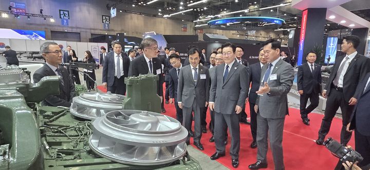 [창원=뉴시스] 강경국 기자 = 이재명 대통령이 20일 ADEX 2025 전시회에서 SNT그룹 부스를 방문해 K2전차 4차 양산 적용 예정인 국산 파워팩에 대한 설명을 듣고 있다. (사진=SNT다이내믹스 제공). 2025.10.20. photo@newsis.com *재판매 및 DB 금지