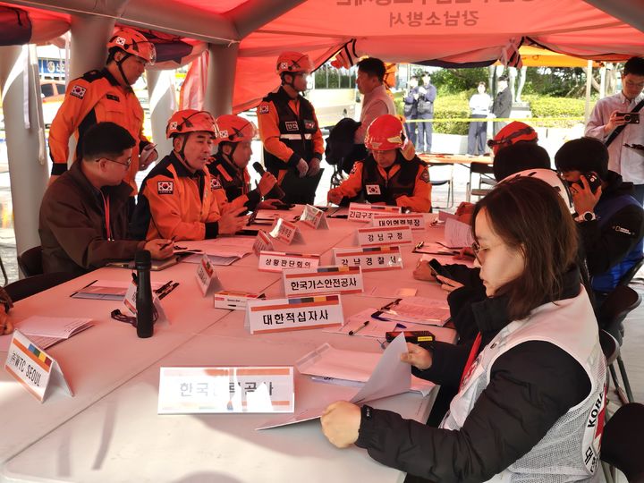 [서울=뉴시스] 조수원 기자 = 2025년 강남구 긴급구조종합훈련이 20일 서울 강남구 코엑스에서 열리고 있다.사진은 긴급구조통제단장을 맡은 강동만 강남소방서장이 현장상황판단 회의를 주재하는 모습.2025.10.20. tide1@newsis.com *재판매 및 DB 금지