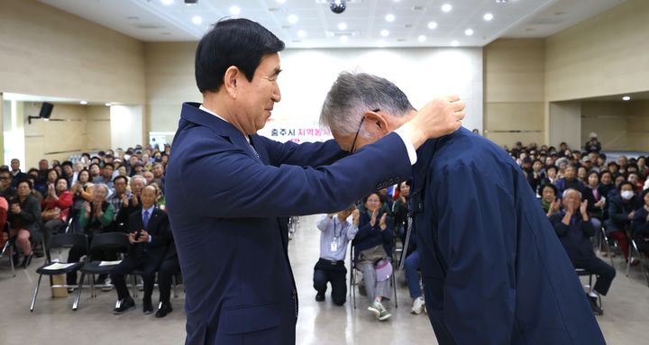 조길형(왼쪽) 충주시장이 20일 지역봉사지도원에게 명찰을 걸어주고 있다. *재판매 및 DB 금지