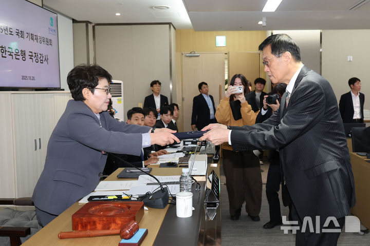 [서울=뉴시스] 권창회 기자 = 이창용 한국은행 총재가 20일 오전 서울 중구 한국은행에서 열린 국회 기획재정위원회의 한국은행에 대한 국정감사에서 선서문을 임이자 기재위원장에게 전달하고 있다. 2025.10.20. kch0523@newsis.com