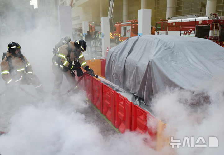 [서울=뉴시스] 배훈식 기자 = 2025 강남구 안전한국훈련 긴급구조 종합훈련이 진행된 20일 오후 서울 강남구 코엑스에서 소방대원들이 전기차 화재진압 훈련을 하고 있다. 2025.10.20. dahora83@newsis.com