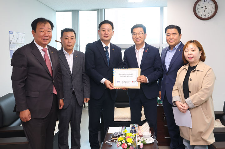 [수원=뉴시스] 경기도의회 여야 의원들이 21일 신정훈 국회 행정안전위원회 위원장에게 지방의회법 제정 촉구 건의안을 전달하고 있다. (사진=경기도의회 제공) 2025.10.21. photo@newsis.com *재판매 및 DB 금지