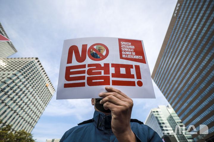 [서울=뉴시스] 정병혁 기자 = 21일 서울 종로구 광화문광장 이순신동상 앞에서 열린 대미 투자강요 트럼프 규탄 대미투자 전면 재검토 각계 시국선언 기자회견에서 참가자들이 피켓을 들고 있다. 2025.10.21 jhope@newsis.com