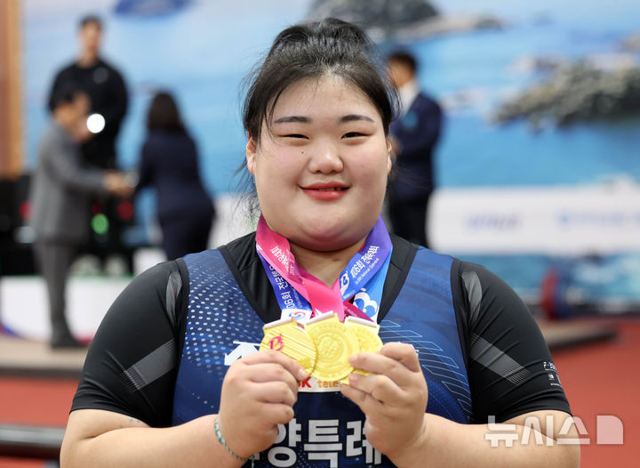  [부산=뉴시스] 하경민 기자 = 제106회 전국체육대회 역도 경기가 열린 21일 부산 남구 국민체육센터에서 여자일반부 +87kg 박혜정(고양시청)이 3관왕을 차지한 뒤 금메달을 들어보이고 있다. 2025.10.21. yulnetphoto@newsis.com