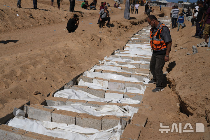 [데이르알발라=AP/뉴시스] 22일(현지 시간) 가자지구 데이르알발라에서 팔레스타인 관계자들이 이스라엘에서 송환된 신원 미상의 팔레스타인인 시신들을 집단 매장하고 있다. 이스라엘은 하마스와 휴전협정에 따라 지금까지 팔레스타인인 시신 150구를 인계한 것으로 알려졌다. 2025.10.23.