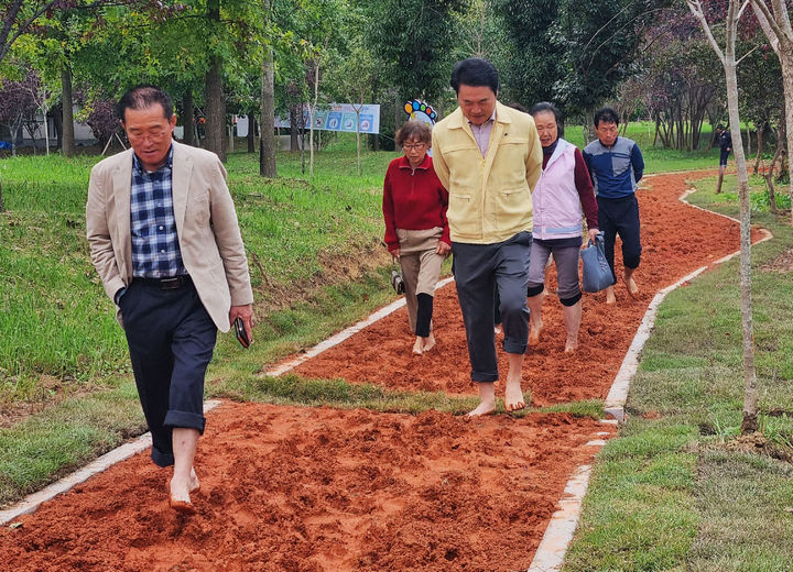 [광주=뉴시스] 광주 광산구가 주민참여예산 사업으로 평동 옥동1근린공원에 조성한 '평동 맨발길'에서 주민들이 맨발 걷기를 하고 있다. (사진 = 광주 광산구 제공) 2025.10.22. photo@newsis.com *재판매 및 DB 금지
