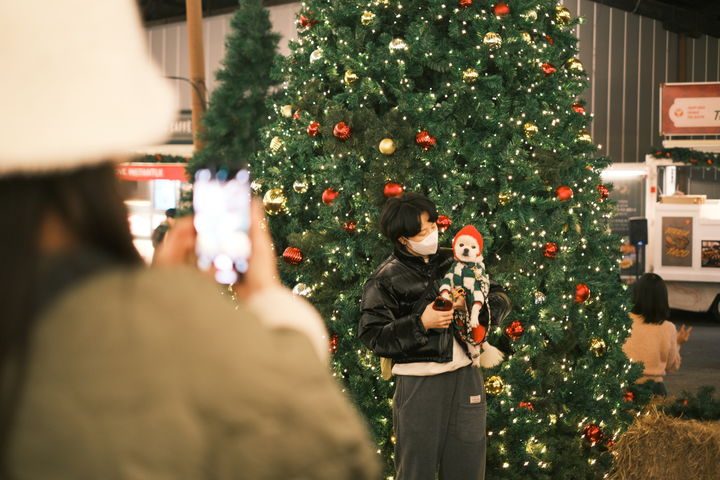 [부산=뉴시스] 지난해 13일부터 29일까지 부산 영도구 소재 스페이스 원지 푸드카페에서 열린 '2024 크리스마스 빌리지 부산' 행사에서 방문객이 반려동물과 함께 사진 촬영을 하고 있다. (사진=영화의전당 제공) 2025.10.22. photo@newsis.com *재판매 및 DB 금지