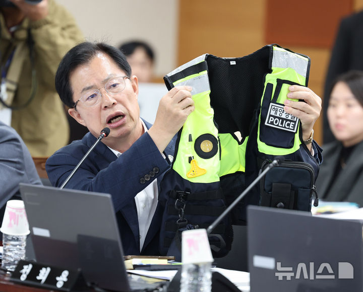 [인천=뉴시스] 전진환 기자 = 이만희 국민의힘 의원이 22일 인천 연수구 해양경찰청에서 열린 국회 농림축산식품해양수산위원회의 해양경찰청 등에 대한 국정감사에서  김용진 해양경찰청장에게 고 이재석 경사의 사망 관련 질의를 하며 순찰용 조끼를 들어보이고 있다  2025.10.22. amin2@newsis.com
