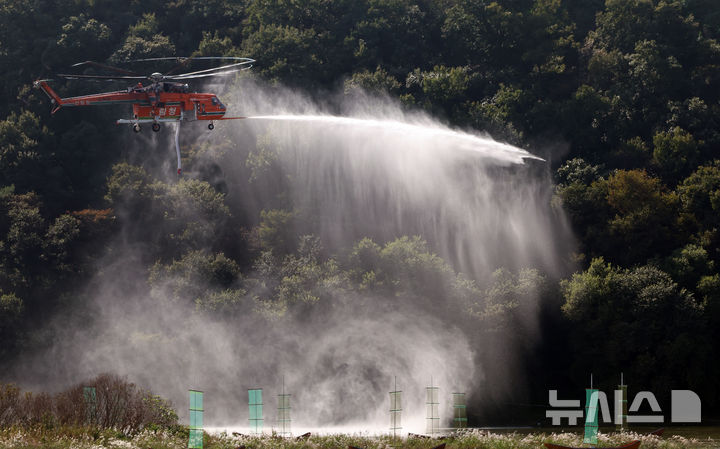 [공주=뉴시스] 강종민 기자 = 22일 충남 공주시 금강변에서 열린 2025 산불진화 통합훈련에서 산불진화헬기들이 방수하고 있다. 2025.10.22. ppkjm@newsis.com