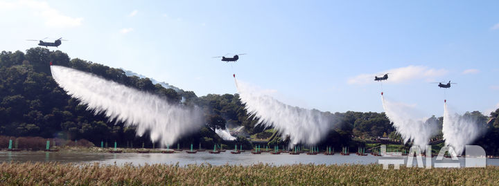 [공주=뉴시스] 강종민 기자 = 22일 충남 공주시 금강변에서 열린 2025 산불진화 통합훈련에서 산불진화헬기들이 방수하고 있다. 2025.10.22. ppkjm@newsis.com