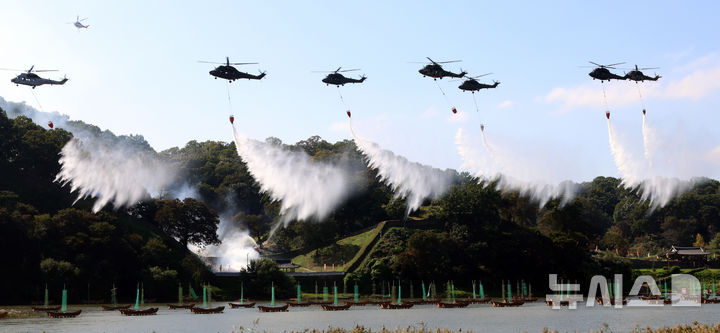 [공주=뉴시스] 강종민 기자 = 22일 충남 공주시 금강변에서 열린 2025 산불진화 통합훈련에서 산불진화헬기들이 방수하고 있다. 2025.10.22. ppkjm@newsis.com