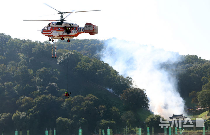 [공주=뉴시스] 강종민 기자 = 지난해 10월 22일 충남 공주시 금강변에서 열린 2025 산불진화 통합훈련에서 산불진화요원이 헬기레펠을 하고 있다. 2025.10.22. ppkjm@newsis.com