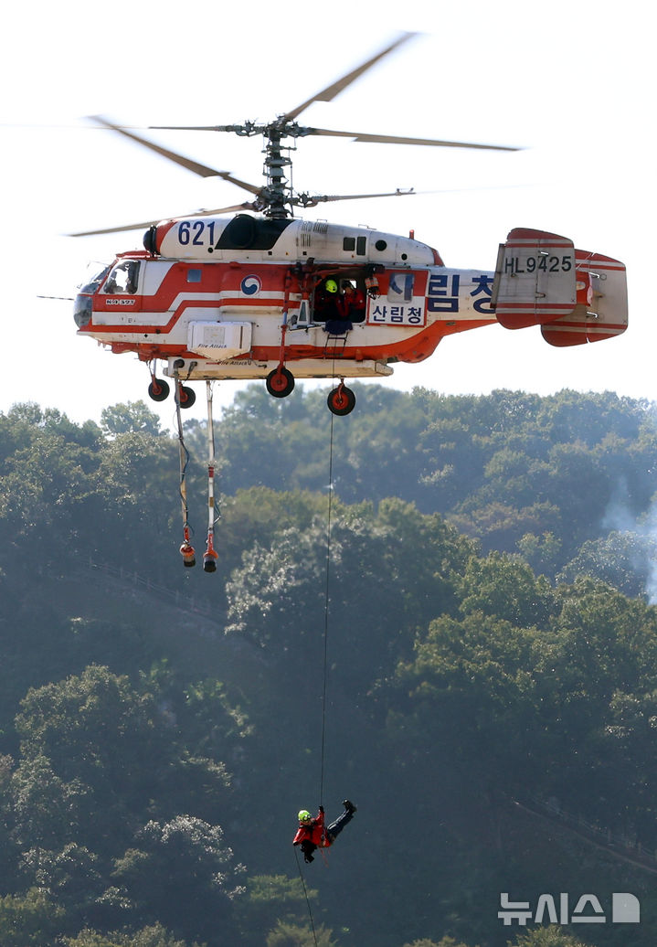 [공주=뉴시스] 강종민 기자 = 22일 충남 공주시 금강변에서 열린 2025 산불진화 통합훈련에서 산불진화요원이 헬기레펠을 하고 있다. 2025.10.22. ppkjm@newsis.com