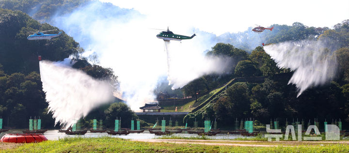 [공주=뉴시스] 강종민 기자 = 22일 충남 공주시 금강변에서 열린 2025 산불진화 통합훈련에서 산불진화헬기들이 방수하고 있다. 2025.10.22. ppkjm@newsis.com