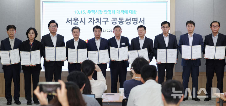 [서울=뉴시스] 김진아 기자 = 국민의힘 소속 15개구 구청장과 부구청장이 22일 서울 중구 서울시청에서 열린 정부의 10·15 부동산 대책에 대한 자치구 공동성명서 발표 기자회견에서 성명서를 들고 기념촬영을 하고 있다. 2025.10.22. bluesoda@newsis.com