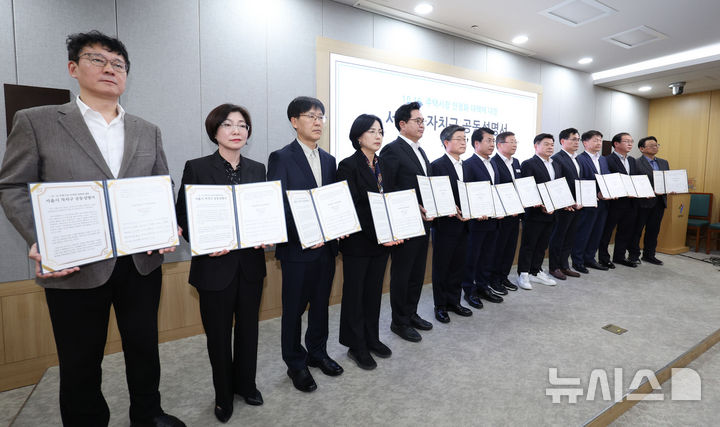 [서울=뉴시스] 김진아 기자 = 국민의힘 소속 15개구 구청장과 부구청장이 22일 서울 중구 서울시청에서 열린 정부의 10·15 부동산 대책에 대한 자치구 공동성명서 발표 기자회견에서 성명서를 들고 기념촬영을 하고 있다. 2025.10.22. bluesoda@newsis.com