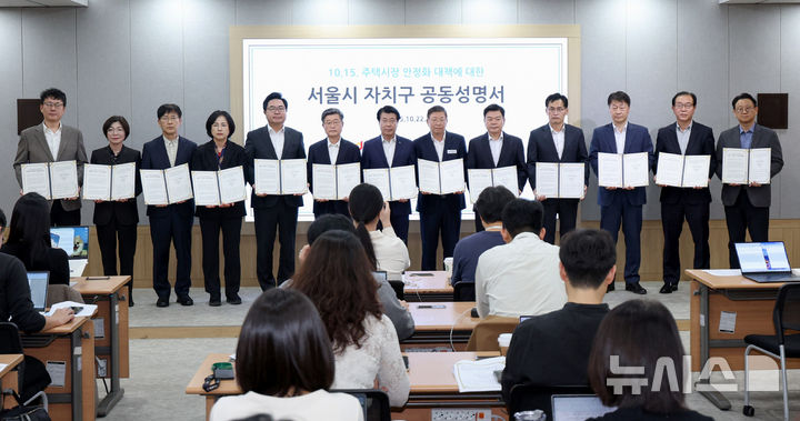 [서울=뉴시스] 김진아 기자 = 국민의힘 소속 15개구 구청장과 부구청장이 22일 서울 중구 서울시청에서 열린 정부의 10·15 부동산 대책에 대한 자치구 공동성명서 발표 기자회견에서 성명서를 들고 기념촬영을 하고 있다. 2025.10.22. bluesoda@newsis.com