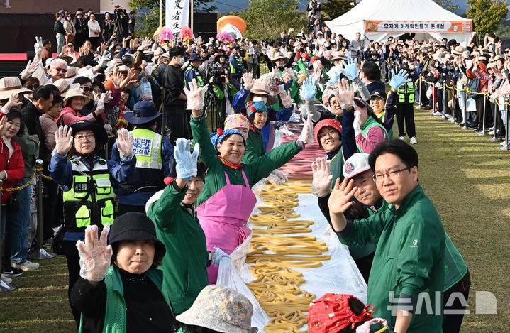 [이천=뉴시스] 김종택 기자 = 제24회 이천 쌀 문화축제가 열린 22일 경기 이천시 모가면 이천농업테마공원에서 새마을부녀회 회원들이 600m 오색가래떡을 만들고 있다. 2025.10.22. jtk@newsis.com