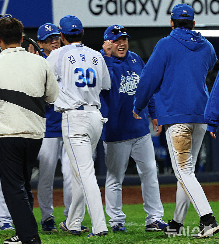 [대구=뉴시스] 최진석 기자 = 22일 대구 수성구 삼성라이온즈파크에서 열린 2025 신한 SOL 뱅크 KBO 포스트시즌 플레이오프 4차전 한화 이글스와 삼성 라이온즈의 경기에서 7대4로 승리한 삼성 박진만 감독과 김영웅을 비롯한 선수단이 승리를 자축하고 있다. 2025.10.22. myjs@newsis.com