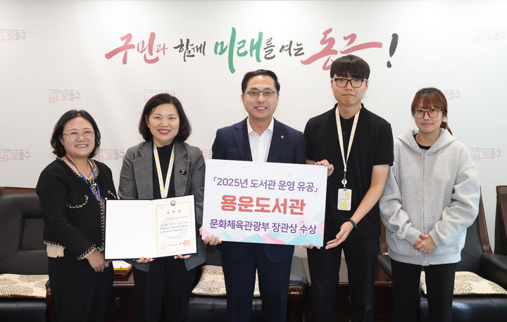 [대전=뉴시스] 조명휘 기자 = 박희조 대전 동구청장과 직원들이 23일 용운도서관이 2025년 도서관 운영 유공 부문에서 문화체육관광부장관상을 받은 것을 기념해 사진을 찍고 있다. (사진= 동구청 제공) 2025.10.23. photo@newsis.com *재판매 및 DB 금지