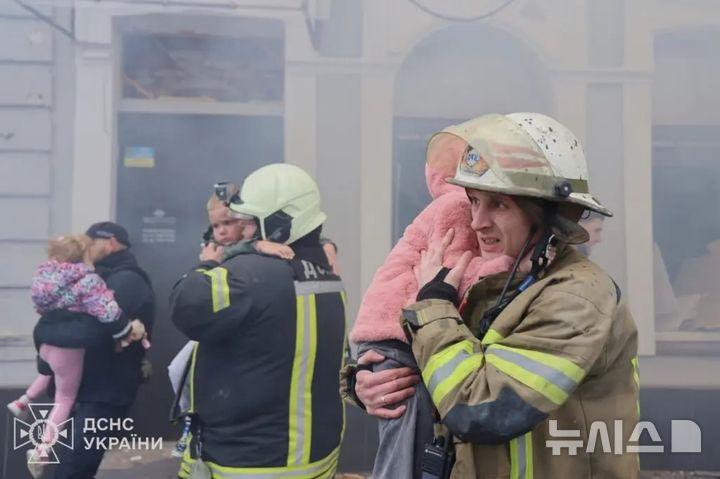 [뉴시스]러시아의 유치원 폭격에 겁에 질린 아이들이 구조대원의 어깨를 붙잡고 있다.(사진=AP)2025.10.22. 