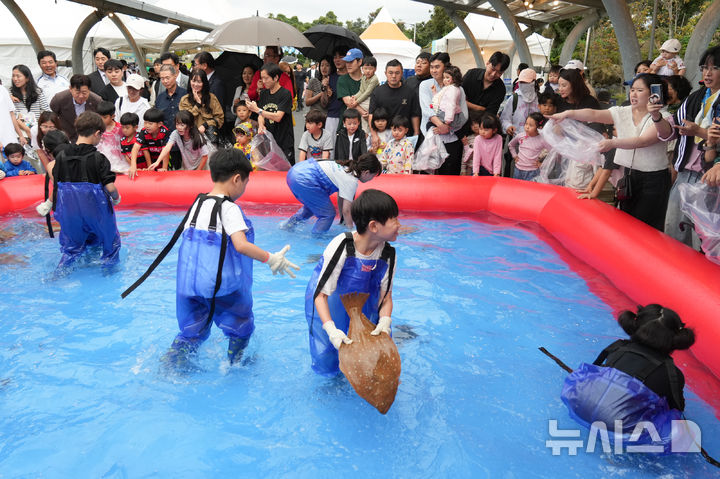 [제주=뉴시스] 제주어류양식수협이 17일부터 19일까지 수협 일원에서 제8회 제주광어대축제를 개최했다. 사진은 어린이들이 광어맨손잡기 체험을 하는 모습. (사진=제주어류양식수협 제공) 2025.10.23. photo@newsis.com 