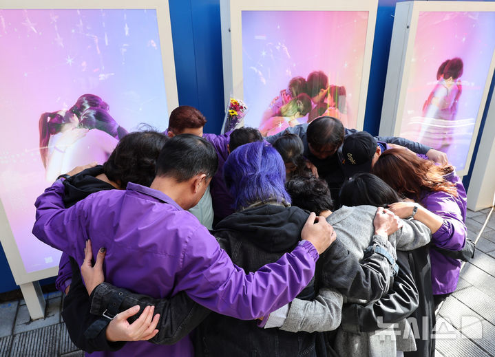 [서울=뉴시스] 배훈식 기자 = 23일 오전 서울 용산구 이태원역 1번 출구 앞 10·29 기억과 안전의 길에서 열린 3주기 빌보드 개막식에서 유가족과 참석자들이 작품 속 아이들처럼 부둥켜 안고 있다. 2025.10.23. dahora83@newsis.com