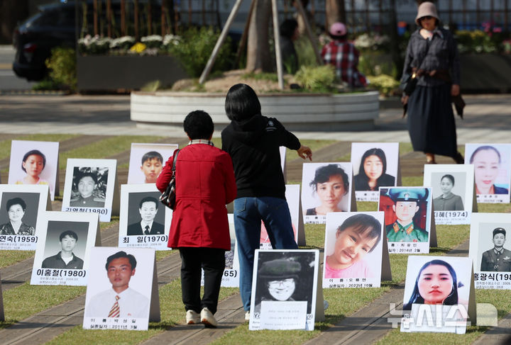 [서울=뉴시스] 조성우 기자 = 지난 10월 23일 오후 서울 중구 서울광장에서 열린 2025 서울북한인권세계대회에서 시민들이 북한에서 실종되거나 북한 실종자 사진을 보고 있다. 2025.12.19. xconfind@newsis.com