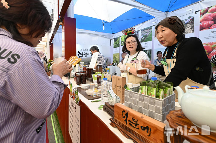 [나주=뉴시스] 이영주 기자 = 국제농업박람회가 개막한 23일 오후 전남 나주시 전남농업기술원 내 박람회장에서 박람회에 참여한 보성 소재 차농가가 차 시음을 권유하고 있다. 2025.10.23. leeyj2578@newsis.com