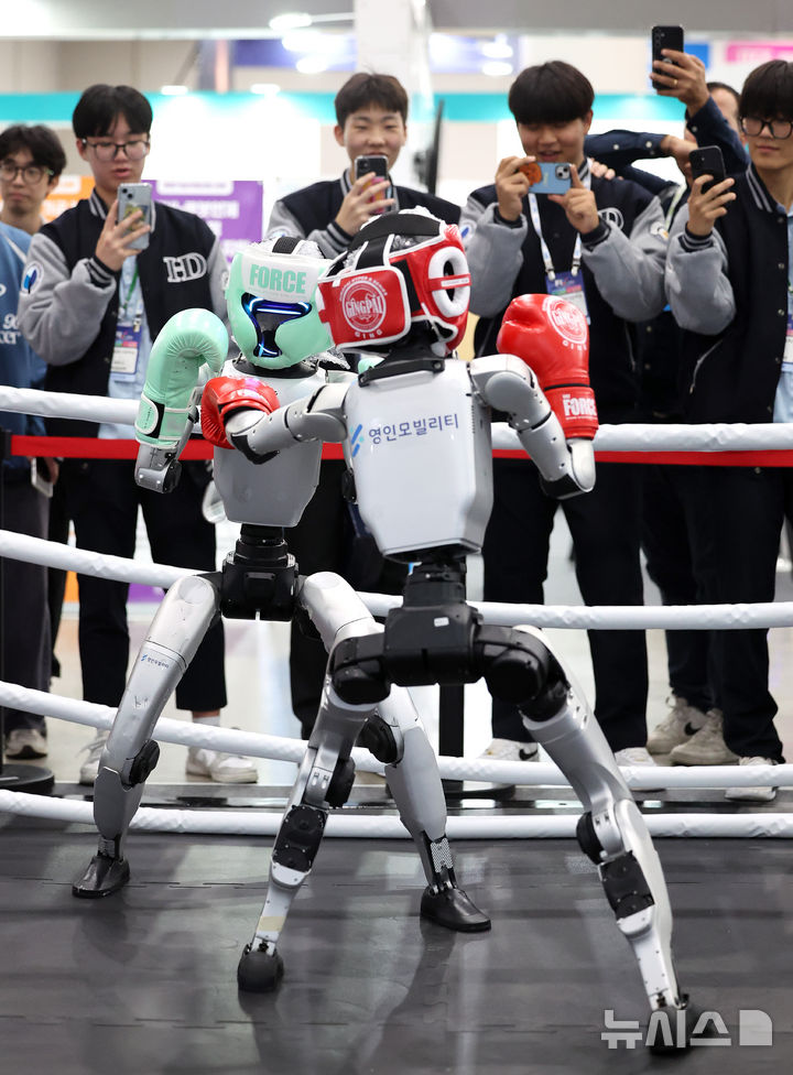 [대구=뉴시스] 이무열 기자 = 23일 대구 북구 엑스코에서 열린 미래혁신기술박람회(FIX 2025)에서 관람객들이 중국 로봇 기업 유니트리 로보틱스(Unitree Robotics)가 개발한 휴머노이드 로봇 'G1' 복싱 경기 시연을 보고 있다.FIX 2025는 미래형 모빌리티와 로봇 산업의 융합을 주제로 25일 까지 엑스코 전관에서 진행된다. 2025.10.23. lmy@newsis.com