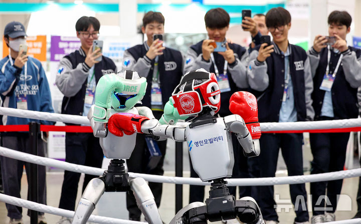 [대구=뉴시스] 이무열 기자 = 23일 대구 북구 엑스코에서 열린 미래혁신기술박람회(FIX 2025)에서 관람객들이 중국 로봇 기업 유니트리 로보틱스(Unitree Robotics)가 개발한 휴머노이드 로봇 'G1' 복싱 경기 시연을 보고 있다.FIX 2025는 미래형 모빌리티와 로봇 산업의 융합을 주제로 25일 까지 엑스코 전관에서 진행된다. 2025.10.23. lmy@newsis.com