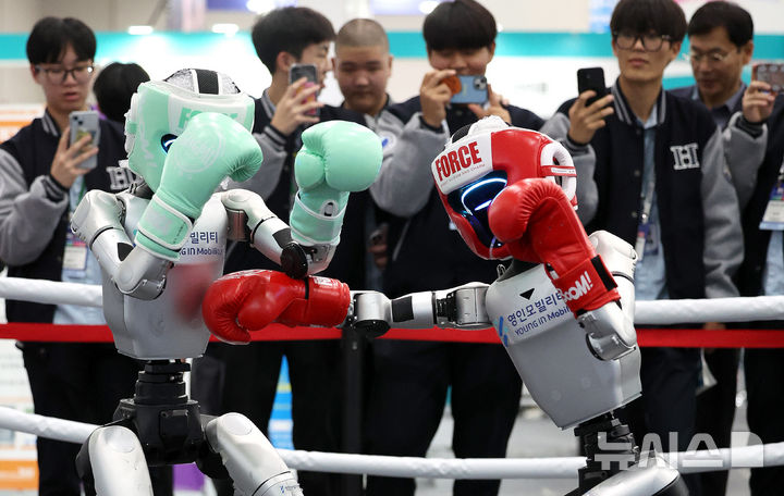 [대구=뉴시스] 이무열 기자 = 23일 대구 북구 엑스코에서 열린 미래혁신기술박람회(FIX 2025)에서 관람객들이 중국 로봇 기업 유니트리 로보틱스(Unitree Robotics)가 개발한 휴머노이드 로봇 'G1' 복싱 경기 시연을 보고 있다.FIX 2025는 미래형 모빌리티와 로봇 산업의 융합을 주제로 25일 까지 엑스코 전관에서 진행된다. 2025.10.23. lmy@newsis.com