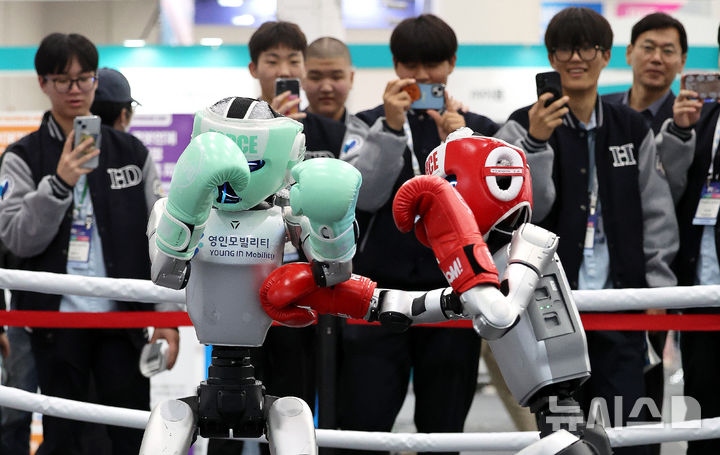 [대구=뉴시스] 이무열 기자 = 23일 대구 북구 엑스코에서 열린 미래혁신기술박람회(FIX 2025)에서 관람객들이 중국 로봇 기업 유니트리 로보틱스(Unitree Robotics)가 개발한 휴머노이드 로봇 'G1' 복싱 경기 시연을 보고 있다.FIX 2025는 미래형 모빌리티와 로봇 산업의 융합을 주제로 25일 까지 엑스코 전관에서 진행된다. 2025.10.23. lmy@newsis.com