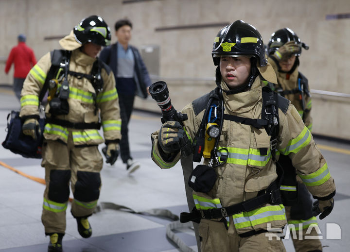 [서울=뉴시스] 김진아 기자 = 지난 10월 23일 서울 동대문구 청량리역 일대에서 진행된 열차 방화·백화점 방화 등 복합 대형 화재 사고 대비 '2025 동대문구 안전한국훈련 긴급구조 종합훈련'에서 소방대원들이 화재진압 훈련을 하고 있다. 2025.10.23. bluesoda@newsis.com