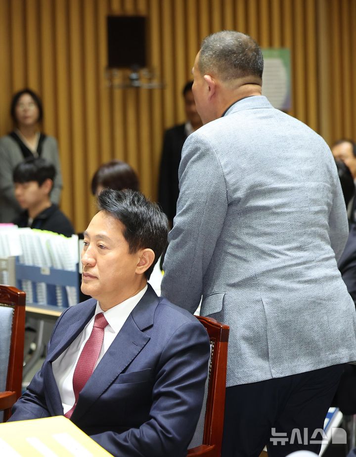 [서울=뉴시스] 김선웅 기자 = '정치브로커'로 알려진 명태균 씨가 23일 서울시청에서 열린 국회 행정안전위원회의 서울특별시에 대한 국정감사에 증인으로 출석해 발언대로 이동하고 있다. 왼쪽은 오세훈 서울시장. 2025.10.23. mangusta@newsis.com