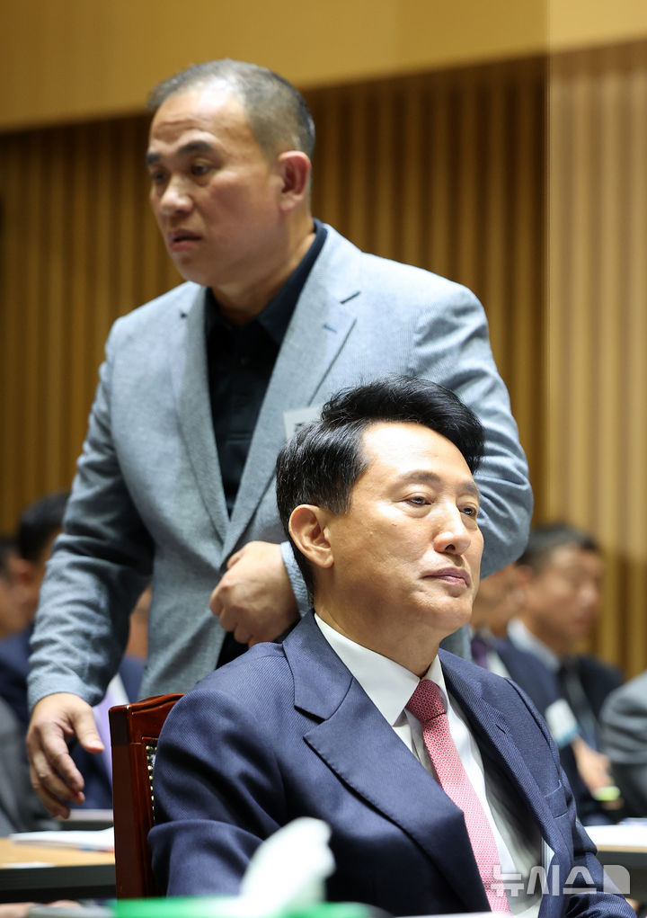 [서울=뉴시스] 김선웅 기자 = '정치브로커'로 알려진 명태균 씨가 23일 서울시청에서 열린 국회 행정안전위원회의 서울특별시에 대한 국정감사에 증인으로 출석해 오세훈 서울시장 뒤를 지나 증언대로 향하고 있다. 2025.10.23. mangusta@newsis.com