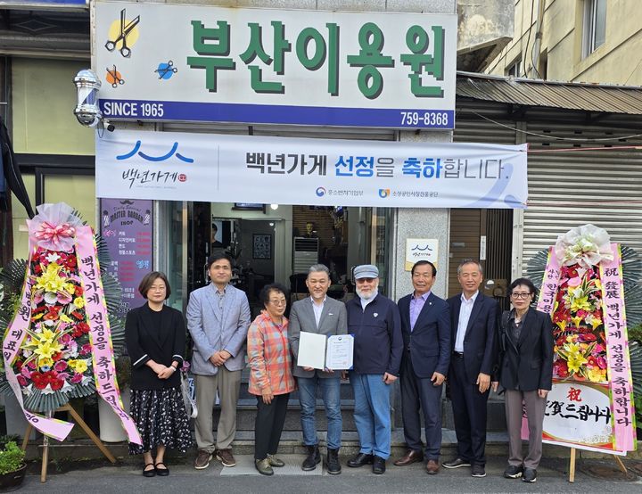 [진주=뉴시스]23일 경남 진주에 위치한 부산이용원이 백년가게로 선정돼 현판식을 갖고 기념사진을 촬영하고 있다.(사진=부산이용원 제공).2025.10.24.photo@newsis.com *재판매 및 DB 금지