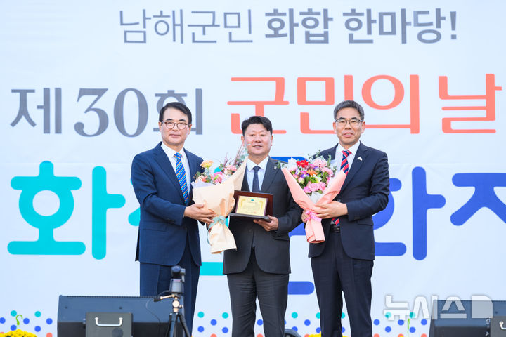 [남해=뉴시스]장충남(왼쪽) 남해군수가 지난 22일 제30회 남해군민의 날 및 화전문화제 개막식에서 박민원 국립창원대 총장에게 '예군민증패'를 전달하고 있다. 오른쪽은 노영식 경남도립남해대학 총장.(사진=국립창원대 제공) 2025.10.24. 